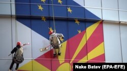 Ilustrativna fotografija: Radnici čiste prozore kancelarija Evropske unije sa zastavama EU i Sjeverne Makedonije u Skoplju, februar 2019.