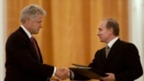 Președintele rus Vladimir Putin (dreapta) și președintele american Bill Clinton schimbă acorduri privind înființarea unui centru comun de avertizare pentru schimbul de informații privind lansările de rachete, la Moscova, pe 4 iunie 2000.