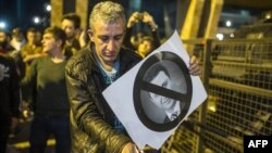 Demonstrant pali sliku Nikole Gruevskog na protestima u Skoplu, 15. april 2016.