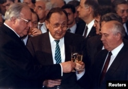 ჰემლუტ კოლი (მარცხნივ), მიხეილ გორბაჩოვი (მარჯვნივ), ჰანს-დიტრიხ გენშერი (ცენტრში). 1990 წლის ნოემბერი