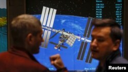 Ljudi ispred fotografije Međunarodne kozmičke agencije pre konferencije o Sojuzu