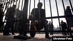 Депутат Верховной Рады Андрей Парубий пилит забор, установленный у парламента. Киев, 18 ноября 2011 года