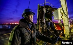 Muncitori efectuează lucrări de întreținere la o sondă de petrol din regiunea Kîzîlorda din Kazahstan.