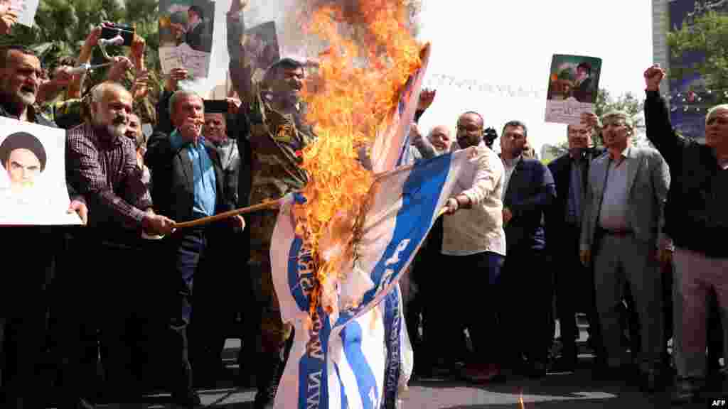 Iranski demonstranti pale izraelske zastave tokom skupa na Trgu Palestine u Teheranu kako bi osudili izraelski nastavak vojnih operacija u Pojasu Gaze prošlog mjeseca.