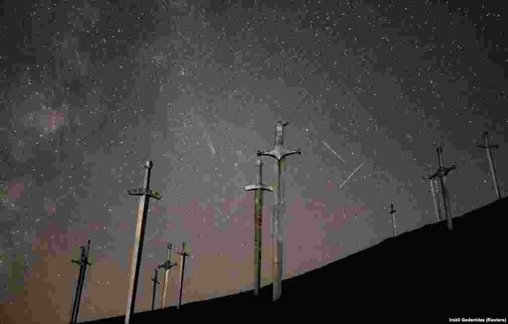 Fotografija prikazuje kometu C/2023 A3-Sučinšan-ATLAS, meteore i tragove satelita na noćnom nebu iznad memorijalnog kompleksa Bitke kod Didgorija u Didgoriju, Gruzija.