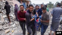 Palestinci nose tijelo muškarca ubijenog u izraelskom napadu u naselju Saftavi zapadno od Džabalije, sjeverno područje Pojasa Gaze, 27. maja 2025.