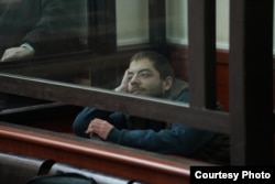 დავით ხომერიკი სასამართლო პროცესზე უსმენს მოწმეს, რომელმაც მას ბრალის შინაარსი გააცნო.