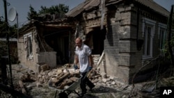 Чоловік прибирає завали перед будинком, який постраждав після обстрілу Росією житлового району в Нікополі, Україна, у понеділок, 22 серпня 2022 року, фото ілюстративне