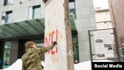 Депутат Олексій Гончаренко пише слово «Nein» на уламку берлінського муру в Києві у знак протесту проти заяви посла