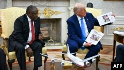 Президент США Дональд Трамп демонстрирует фотографии якобы убитых белых африканеров на встрече с президентом ЮАР Сирилом Рамафосой в Овальном кабинете Белого дома. Вашингтон, 21 мая 2025 года