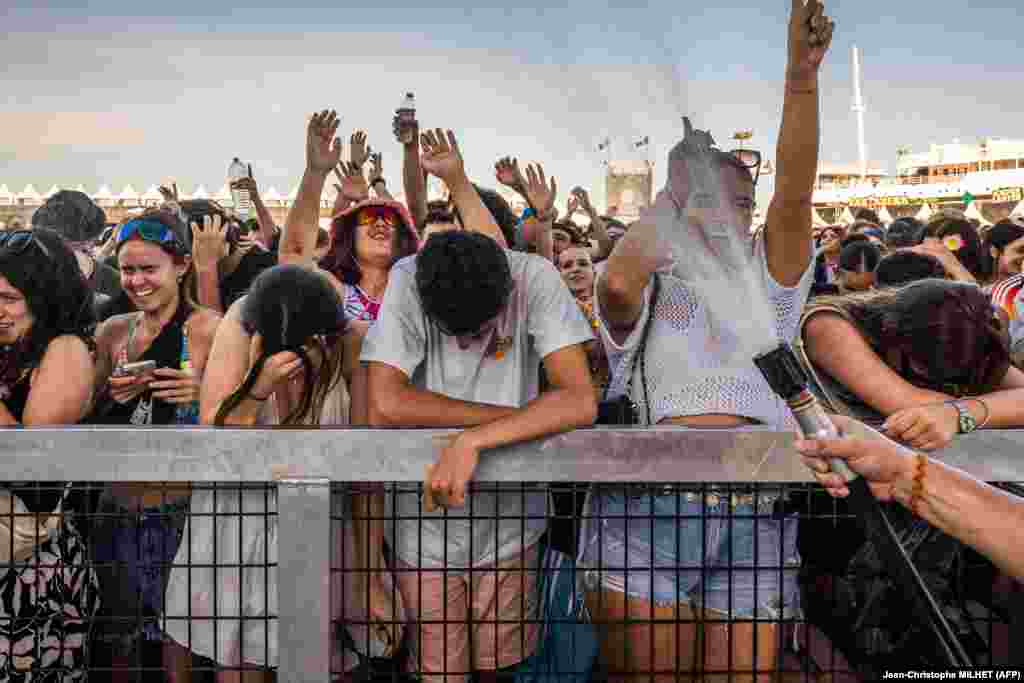 Një punonjës duke i flladitur pjesëmarrësit në festivalin e muzikës Les Deferlantes, në Le Barkares, Francë, më 29 qershor.