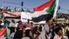 SUDAN -- Sudanese demonstrators march with national flags as they gather during a rally demanding a civilian body to lead the transition to democracy, outside the army headquarters in the Sudanese capital Khartoum on Saturday, April 13, 2019.