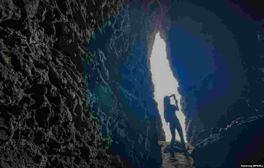 Туристка в Сквозном гроте &shy;&ndash; достопримечательности Капчика, середина октября 2024 г., Новый Свет, Крым.