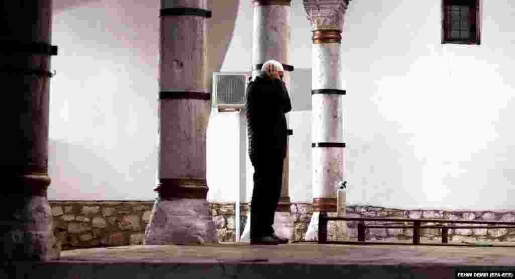 Верующий во время молитвы перед мечетью в Сараево, Босния и Герцеговина.