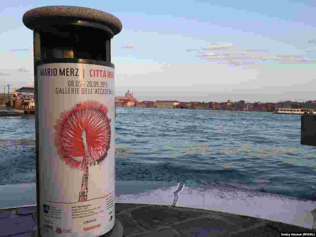 Набережная Дзаттере на закате. На афише – реклама выставки Марио Мерца