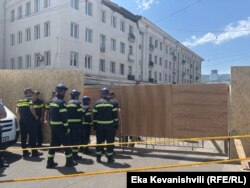 სამაშველო სამსახურის თანამშრომლები შედიან შემოღობილ ტერიტორიაზე.