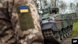 უკრაინელი ჯარისკაცი საბრძოლო მანქანასთან საწვრთნელ ზონაში, მიუნსტერში. გერმანია. 2023 წლის 20 თებერვალი.