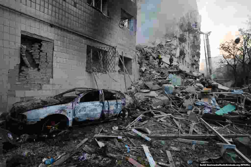 Zapaljeni automobil pored urušenog dijela stambene zgrade u Kijevu.