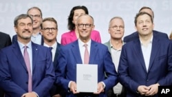 Kancelari i ardhshëm i Gjermanisë, Friedrich Merz (në mes) dhe partnerët e tij në koalicionin qeverisës, fotografohet pasi nënshkruan marrëveshjen për bashkëqeverisje, 5 maj.