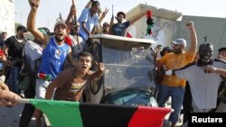 Libijski pobunjenici sa kolima za golf koja su pripadala Moameru Gadafiju, 23. avgust 2011.