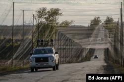 Автомобиль, оснащенный системой РЭБ, едет по дороге, накрытой сетью для защиты от дронов на востоке Украины, 2 октября