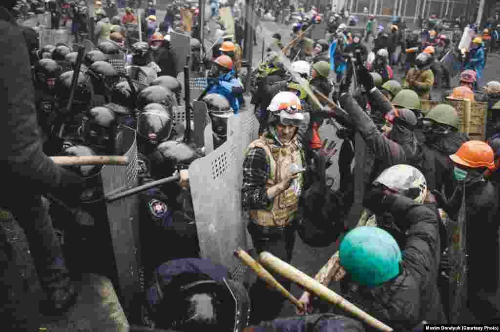 Доброволец пытается разъединить милицию и демонстрантов. 