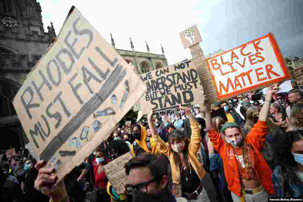 Демонстранты держат плакаты с призывом демонтировать статую деятеля британского империализма, шестого премьер-министра Капской колонии Сесила Джона Родса, расположенную в одном из колледжей Оксфордского университета. В письме 26 представителей мэрии написали, что она "несовместима" с "приверженностью города антирасизму". Оксфорд, Великобритания, 9 июня
