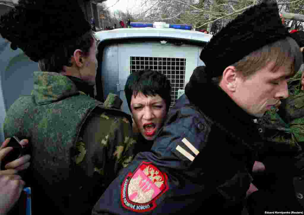 6 марта 2014, Симферополь. Участники «крымской самообороны» блокируют активистку Femen во время антивоенной акции у здания крымского парламента