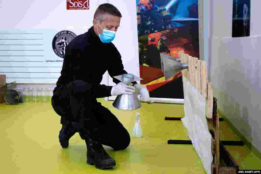Policajac natapa komade tkanine uzorcima bakterije COVID-a 19 kako bi pripremio psa da nauči prepoznati miris korona virusa u Maison- Alfort, na periferiji Pariza, 13. svibnja.