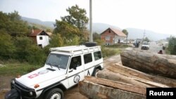 Vozilo KFOR-a prolazi pored delimično uklonjene barikade u selu Zupče, 27. oktobar 2011.