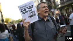 Demonstrant drži papire na kojima piše "Gaza, zaustavite genocid" tokom protesta protiv rata na palestinskim teritorijama Gaze, 13. juna 2024. godine u Barceloni.