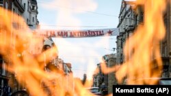 Vječna vatra u Sarajevu i plakat na kojem piše "Ja sam antifašista" tokom protesta protiv mise za žrtve u Blajburgu koja je održana u katedrali u Sarajevu