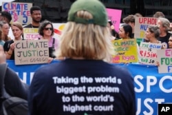 Activiști cerând „dreptate climaterică” în fața sediului din Haga al Curții ONU, la 23 iulie 2025.