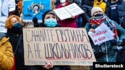 Жена държи плакат с надпис: "Пратете в затвора Путин, а не учениците". Снимка от протестната демонстрация в защита на Алексей Навални в Прага на 23 януари 2021 г.