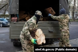 Российские военные в Симферополе загружают в грузовик спиленные деревья в рамках акции «Блиндажи в тепле», февраль 2025 года
