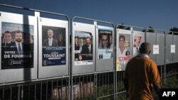 Čovjek prolazi pored izbornih plakata uoči parlamentarnih izbora, Bordo, Francuska 25. juna 2024.
