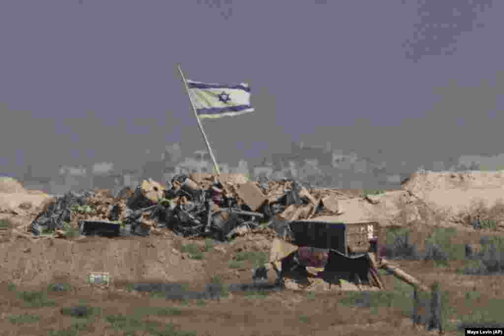 Izraelska zastava se vijori iznad ruševina u području Pojasa Gaze, fotografisana iz južnog Izraela, 26. avgusta.