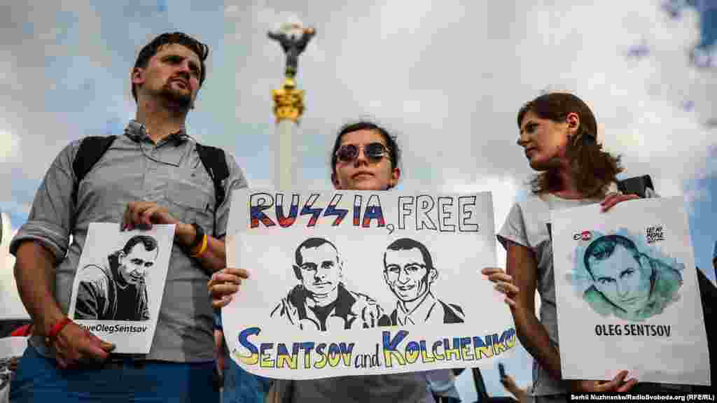 Демонстранти тримають в руках плакати із закликом звільнити українського кінорежисера Олега Сенцова і Олесандра Кольченка на площі Незалежності у Києві 13 липня. У серпні 2015 року Олег Сенцов і Олександр Кольченко були визнані винними у справі про створення терористичного співтовариства, вчиненні та плануванні терактів на території анексованого Криму. Сенцов отримав 20 років колонії суворого режиму, Кольченко – 10 років колонії. Обидва засуджених свою провину заперечують. Правозахисники визнали їх політв’язнями. (Сергій Нужненко, Радіо Свобода/Радіо Вільна Європа) 