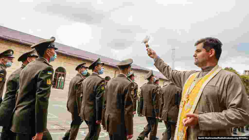 Священник окроплює святою водою курсантів