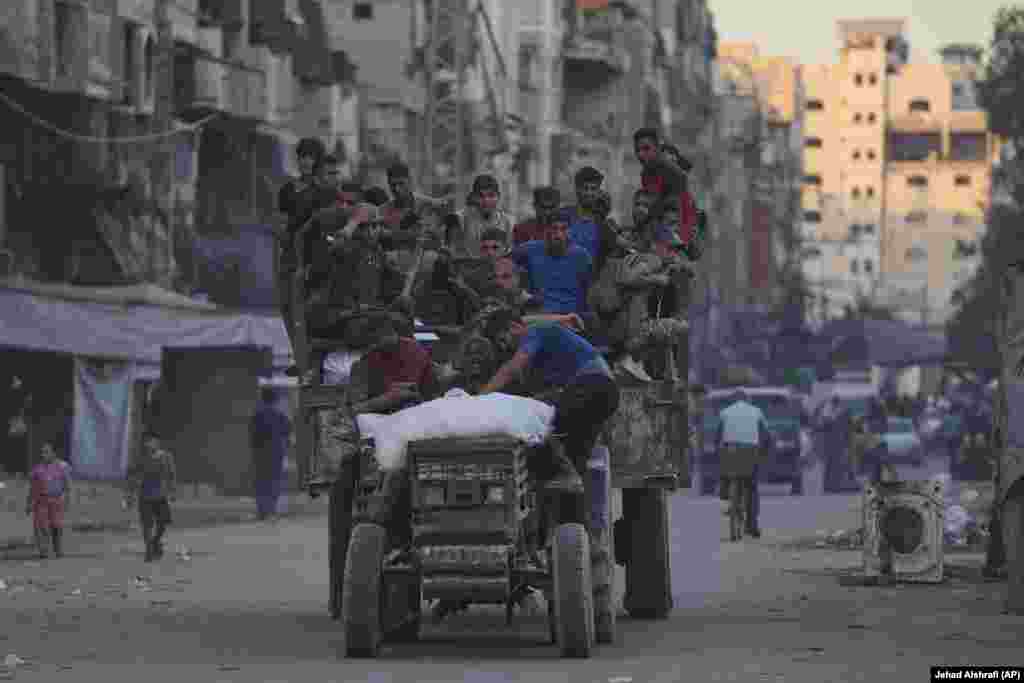 Palestinci na prikolici traktora koji prevozi pomoć dostavljenu iz sjevernog pojasa Gaze, voze se ulicom u gradu Gazi, 29. avgusta.