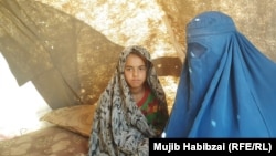 Soraya (right) sits with her younger sister inside a tent at a makeshift camp for internally displaced persons (IDPs) in the northern province of Balkh.