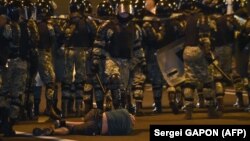 Demonstrant na ulici ispred snaga bezbednosti na opozicionim demonstracijama u Minsku, 9. avgust 2020.