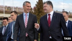 Ukrainian President Petro Poroshenko (right) speaks with NATO Secretary-General Jens Stoltenberg (left) during a welcoming ceremony in Lviv on September 21.