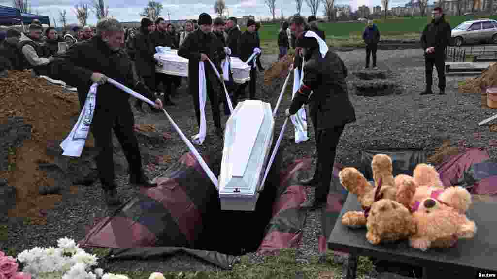 Ožalošćeni prisustvuju pogrebnoj ceremoniji 7. aprila za dvoje djece koja su ubijena u ruskom raketnom napadu na ukrajinski grad Krivij Rih tri dana ranije.