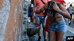 O fată se răcorește cum poate la Vatican, pe 28 iunie 2025.