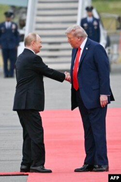 Președintele SUA, Donald Trump (dreapta), îl salută pe președintele rus Vladimir Putin pe pista aeroportului după sosirea celor doi la Baza Elmendorf-Richardson din Anchorage, Alaska, pe 15 august 2025.