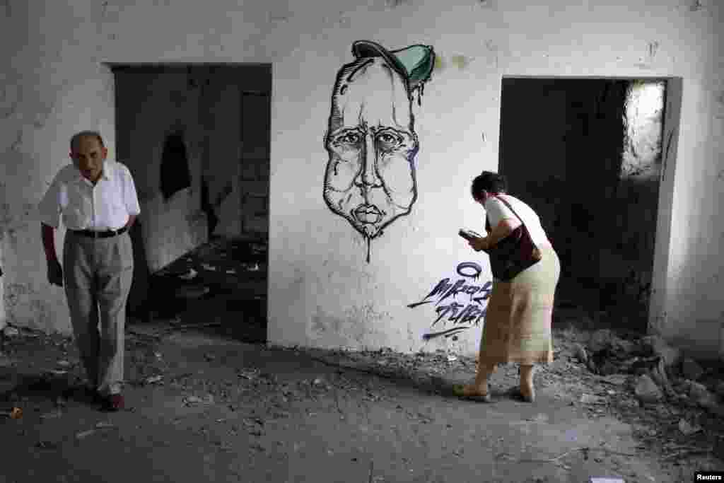 Teodor Kovač i Marijana Sibinović u unutrašnjosti napuštenih i urušenih prostorija, Beograd, 29. juli 2013. Foto: REUTERS / Marko Đurica