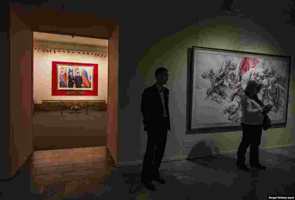 Выставку открывает совместное фото Владимира Путина и Ким Чен Ына. Сотрудничество с Россией стало особенно активно пропагандироваться северокорейским режимом после того, как тысячи военнослужащих КНДР были отправлены на фронт, чтобы поддержать агрессивную войну Кремля.