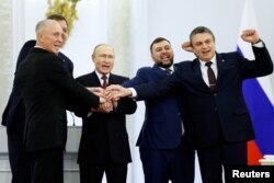 Ruski predsednik Vladimir Putin i lideri koje je postavila Rusija u ukrajinskim regionima Donjeck, Lugansk, Herson i Zaporožje slave na ceremoniji potpisivanja 30. septembra.