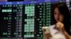 Žena pored ploče s prosječnim cijenama dionica na Tajvanskoj berzi u Tajpeju 7. aprila 2025.